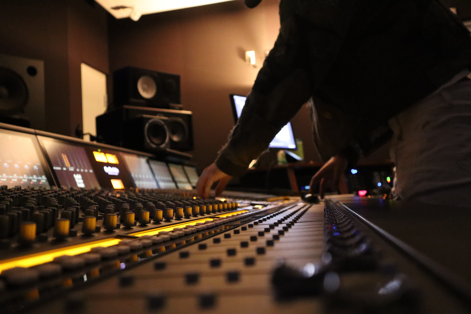 Hands on a large-format analog console during a mix session